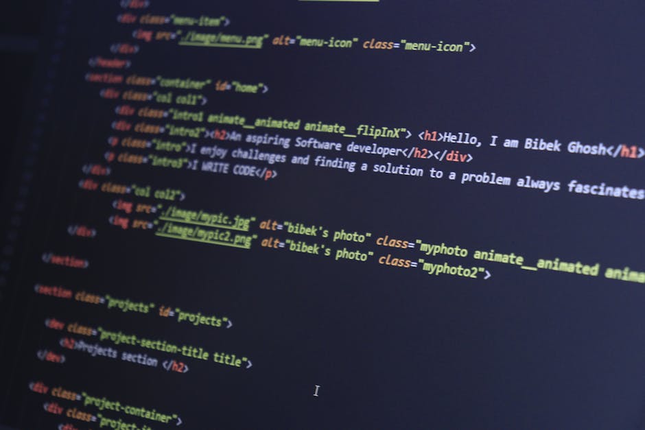 Close-up view of a computer screen displaying lines of colorful HTML and CSS code with syntax highlighting in various colors, including green, yellow, purple, and blue. The code appears to be related 